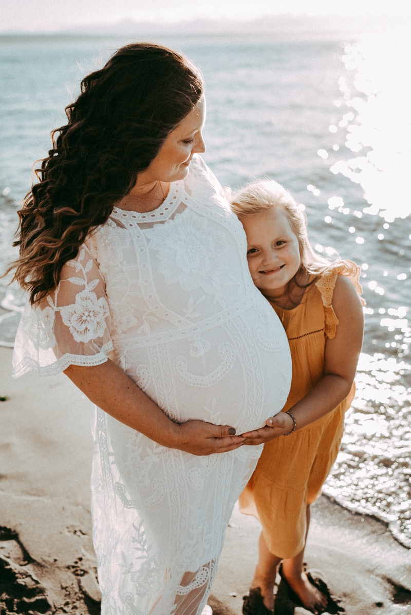 Seattle Maternity Photography, Mother-to-be and her daughter walk in the sand