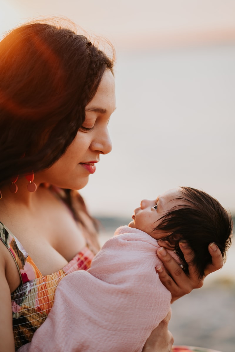 Seattle Motherhood Photography, a young woman holds her newborn baby close, she's a mom