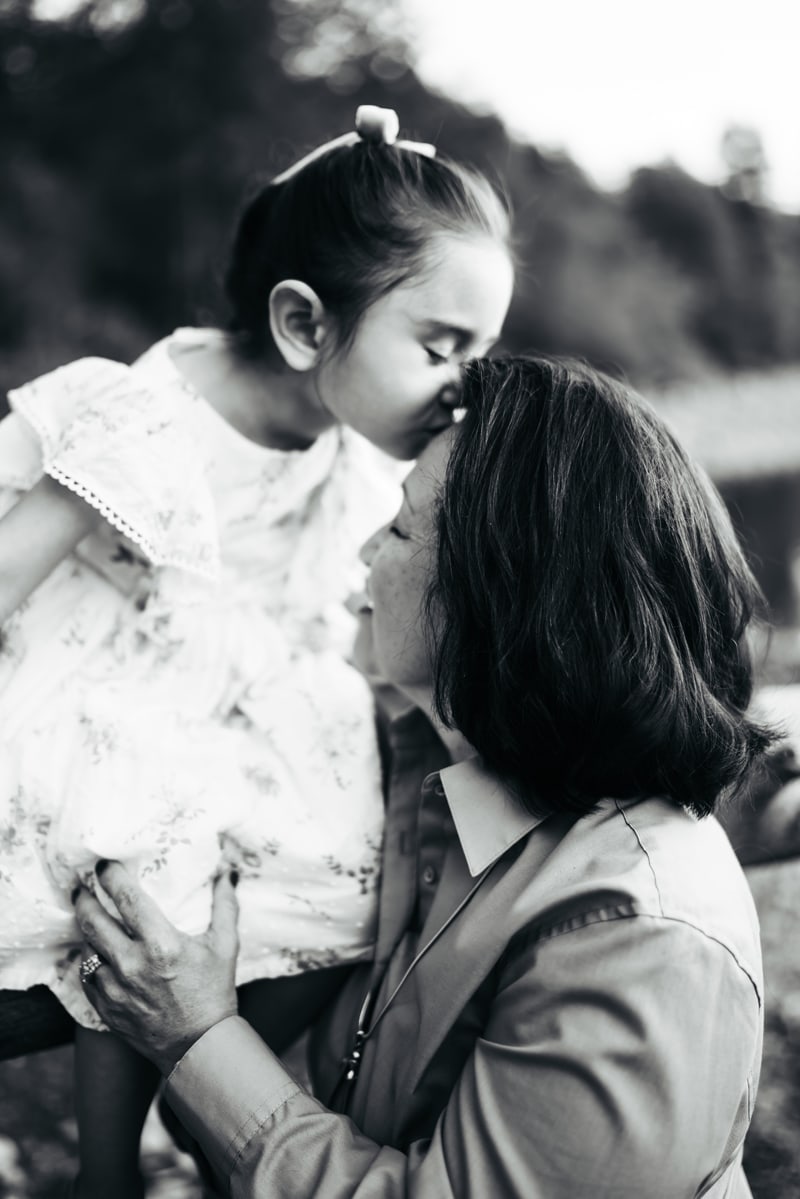 Seattle Grandparent Legacy Photography, grandmother receives a kiss from her granddaughter on the forehead outdoors