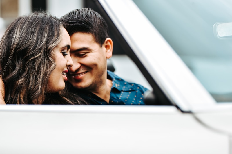 Seattle Couples Photography, a man and woman smile as they lean into each other face to face, they are sitting in their car