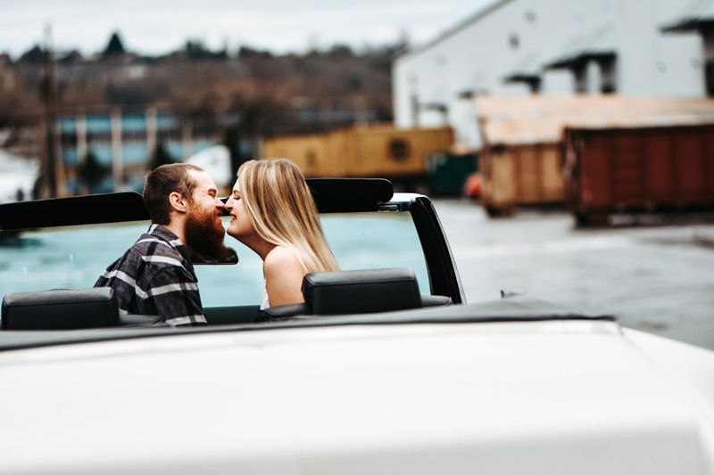 Seattle Couples Photography, man and woman sit in a convertible together, they smile as they draw nose to nose