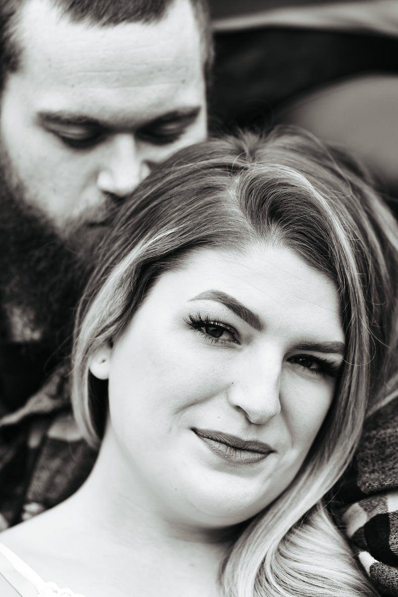 Seattle Couples Photography, a man sits behind his wife and leans gently into her, she's happy