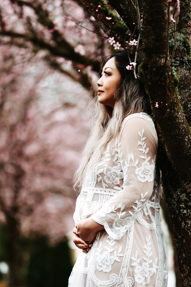 Seattle Maternity Photography, expecting mother leans against cherry blossom tree